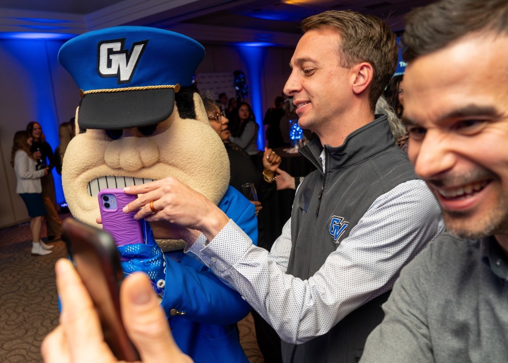 Alumni House employees Alex and Kyle with Louie the Laker as they take pictures